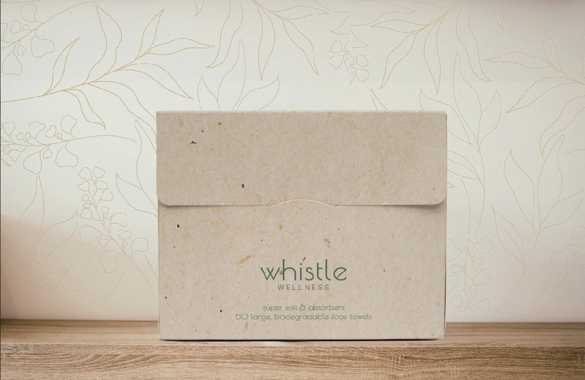 Whistle XL face towel dispenser box on a wooden surface